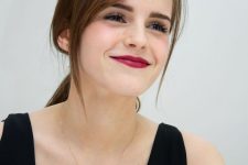 Emma Watson rocking light brunette hair in a low ponytail and side bangs looks gorgeous