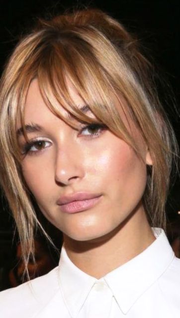 Hailey Baldwin wearing blonde hair with highlights and bottleneck bangs looks chic and very girlish