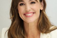 Jennifer Garner wearing long brunette hair with caramel highlights and waves and side bangs looks gorgeous