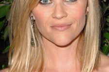 Reese Witherspoon wearing medium length blonde hair with highlights and side bangs looks fabulous