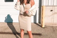 With beige sleeveless knee-length dress, beige crop jacket and white high heel boots