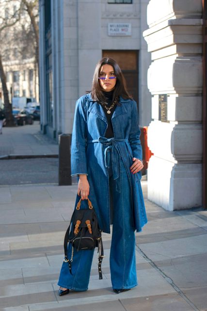 With black turtleneck, golden necklace, denim palazzo pants, black leather pumps and black and brown backpack