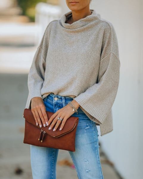 With jeans and brown leather clutch