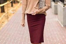 With leopard printed clutch, marsala knee-length skirt, beige leather pumps and oversized sunglasses