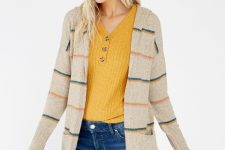 With mustard yellow V-neck sweater and navy blue jeans