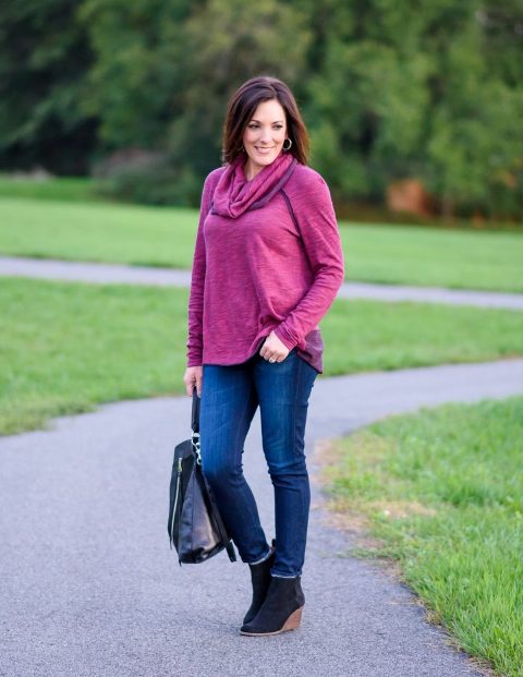 With purple cowl neck loose shirt, navy blue jeans and black leather backpack