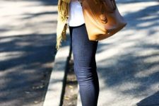 With white loose sweater, mustard yellow fringe scarf, brown leather tote bag and navy blue skinny cuffed jeans