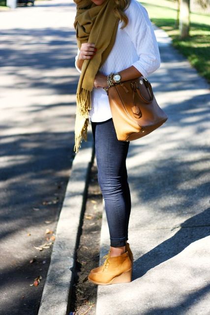 With white loose sweater, mustard yellow fringe scarf, brown leather tote bag and navy blue skinny cuffed jeans