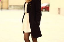 With white pleated belted mini dress, beige scarf and black knee-length coat