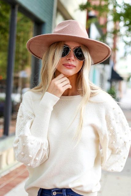 With white pom pom sweater, sunglasses and jeans
