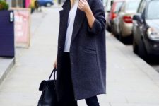With white shirt, sunglasses, black skinny pants, black leather tote bag and dark colored knee-length coat
