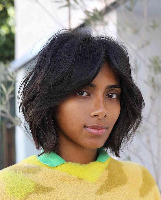 a black dimensional bob with bottleneck bangs and textured hair is a chic and cool idea to rock