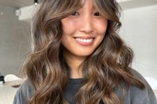 a long brunette butterfly haircut with caramel and bronde balayage with bottleneck bangs and waves is a chic idea