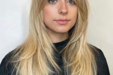 a long layered blonde haircut with bottleneck and curtain bangs is a very chic and beautiful solution
