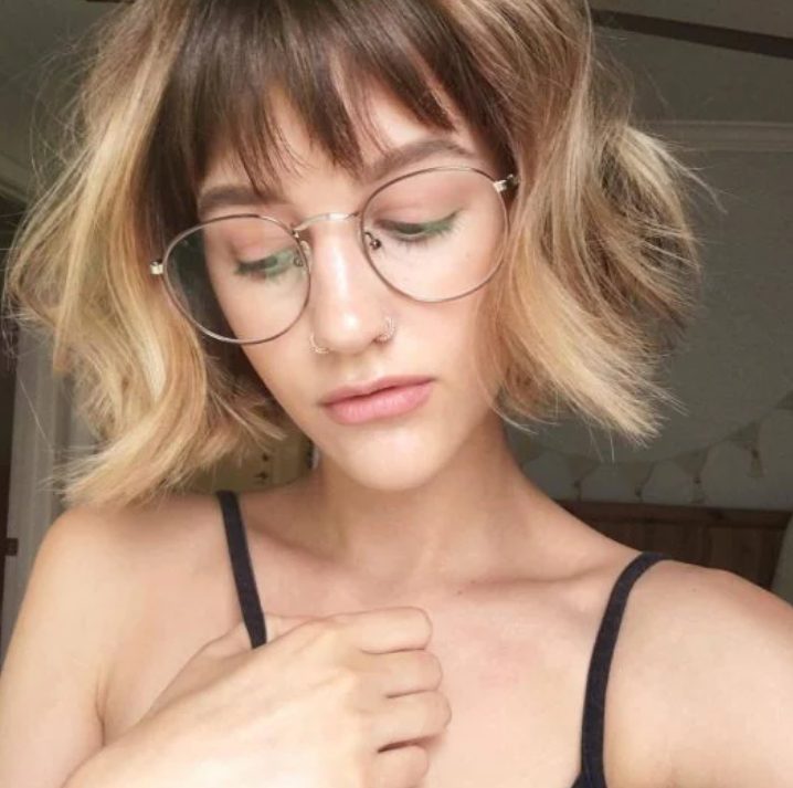 a short blonde bob with dark lowlights and see through wispy bangs is a stylish way to gain extra points