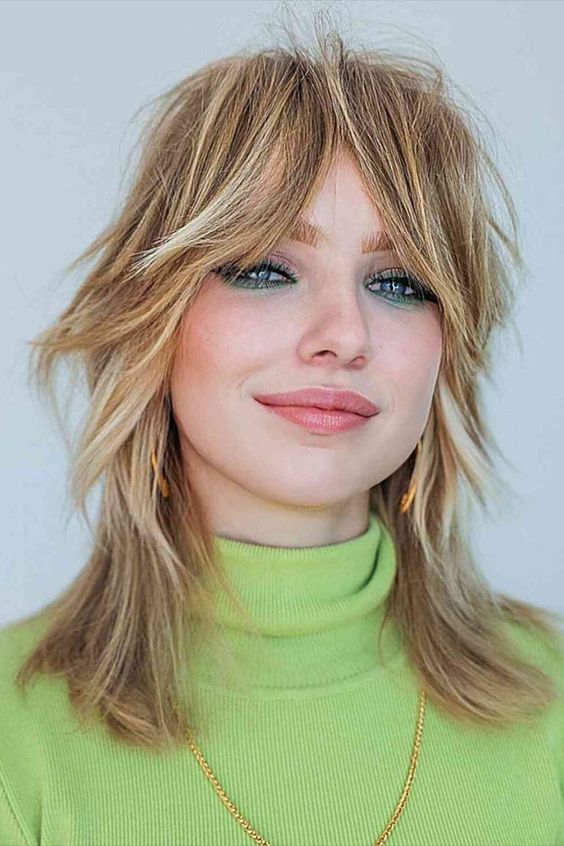 a super cool messy shaggy medium wolf cut with long bottleneck bangs and blonde balayage is a cool way to stand out
