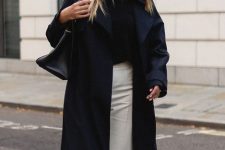 a transitional look with a black tee, white pants, a navy coat and a black tote for those who love contrasts
