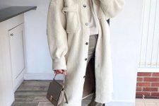 a white jumper, grey jeans, white Chelsea boots, a long white shirt jacket and a grey bag for a cold day