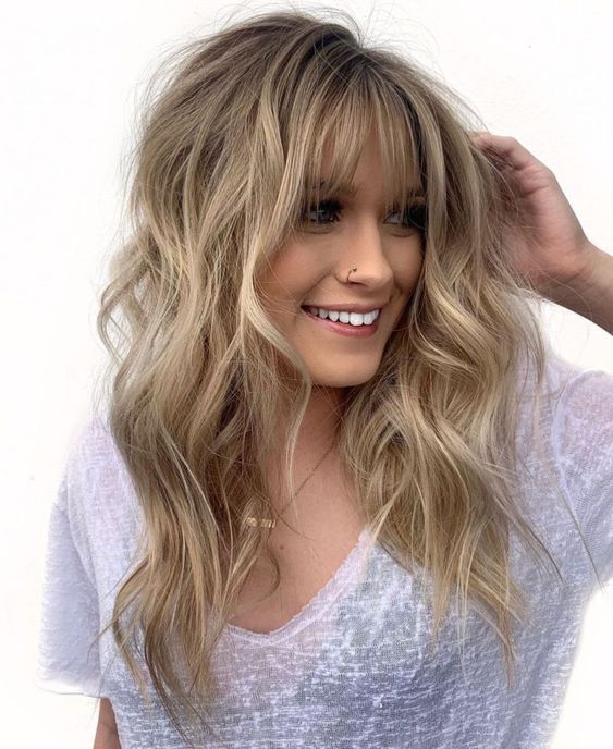 amazing long wavy londe hair with texture and with balayage plus layered bangs for a chic touch