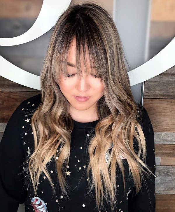 beautiful long caramel blonde hair with darker lowlights and a dark root plus waves and wispy bangs for a touch of romance