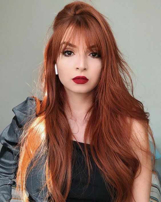 bold long red hair with wispy bangs for subtle face framing and to make a delicate touch with this hair color