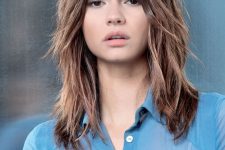 chestnut shaggy shoulder length hair with balayage and shaggy layered bangs that add a more messy touch to the look