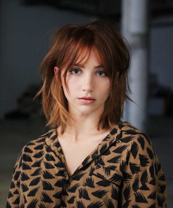 copper red medium length hair with an ombre effect and bottleneck bangs is a beautiful and textural idea
