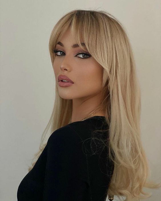fab long blonde locks with bottleneck bangs and a bit of delicate volume is a stunning solution with an elegant feel