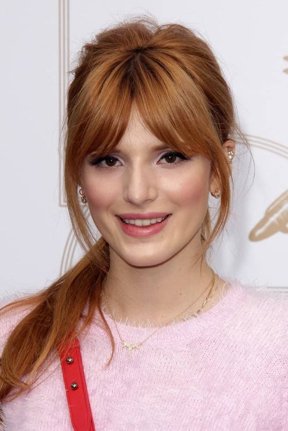 gorgeous ginger red hair in a ponytail with some volume on top and beautiful layered banfs that frame the face perfectly
