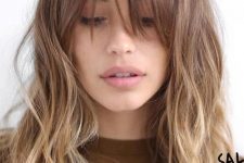 light brown hair with an ombre effect to blonde, a layered haircut and wispy outgrown bangs for a feminine touch