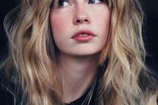 long blonde wavy hair with bottleneck bangs and a lot of volume looks very messy, chic and sexy
