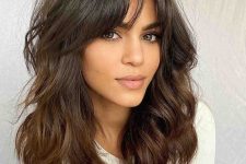 medium length dark chocolate hair with waves and texture and bottleneck bangs for a catchier look