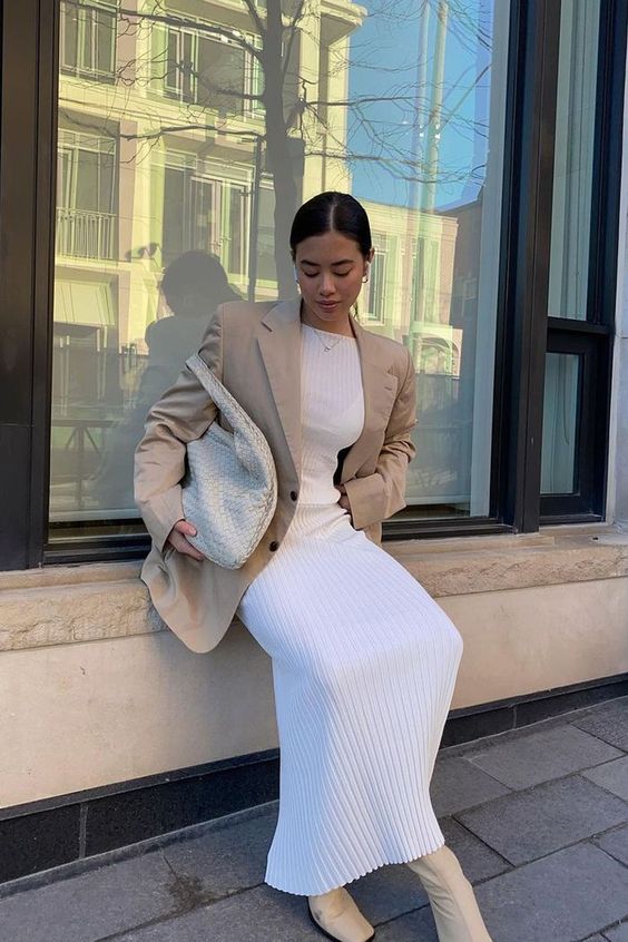 a beautiful neutral spring outfit with a pleated mxi dress, a tan oversized blazer, tan booties and a creamy woven tote