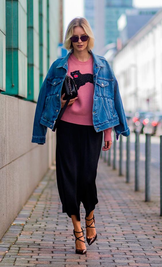 a black midi skirt, black strappy shoes, a pink printed jumper, a blue denim jacket and a black bag for a bright look