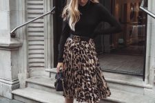 04 a black turtleneck, a leopard printed pleated midi skirt, tan shoes and a black mini bag for a simple and bold look