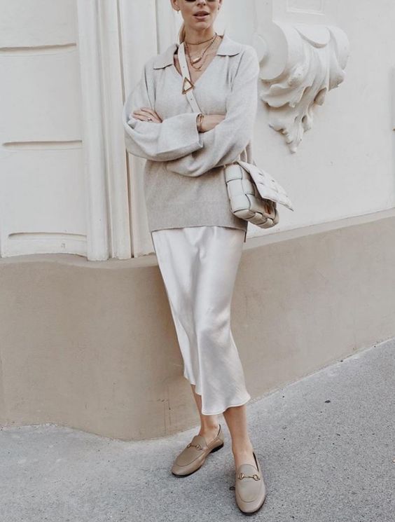 a dove grey jumper with a V-neckline, a white slip midi, grey loafers, a creamy woven bag for every day