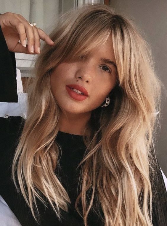 long blonde locks with a darker root and texture plus bottleneck bangs looks gorgeous and amazing