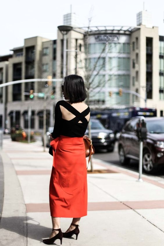 a bold and sexy outfit with a black criss cross bag top, a red midi skirt, black velvet heels and a cognac bag