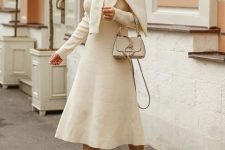 06 a neutral knit midi A-line dress, a creamy sweater on top, tan boots and a creamy mini bag plus statement earrings