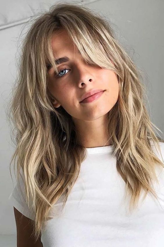 beautiful shaggy shoulder-length hair with icy blonde balayage and bottleneck bangs for more softness and cuteness in the look