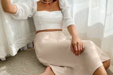 07 a girlish outfit with a white draped crop top with puff sleeves, a plain blush midi skirt and layered necklaces