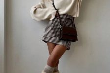 09 a neutral oversized jumper, a printed mini skirt, creamy knee boots and tall socks plus a burgundy bag