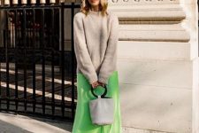 09 a tan jumper, a neon green slip midi skirt, white strappy heels, a white bucket bag and cool sunglasses