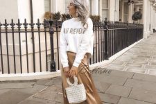 10 a white printed jumper, a gold midi slip skirt, white trainers and a white bag with round handles