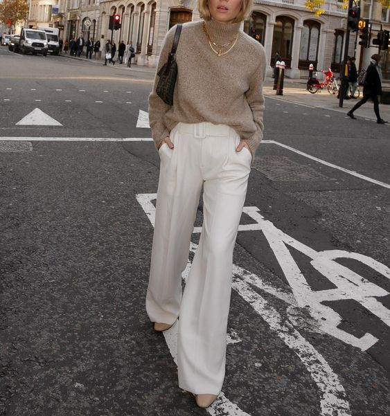a simple and cool outfit with a grey turtleneck sweater, creamy high waisted trousers, grey boots and a small black bag