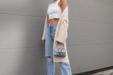13 a white crop top, blue jeans, grey embellished sohes, a neutral cardigan and a snakeskin printed bag