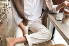 15 a white long-sleeve top, neutral trousers, a brown jumpser and tan loafers for a comfy spring look