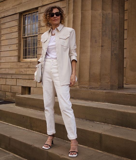 an elegant work look with white jeans, a white t-shirt, a neutral shirt jacket, a neutral bag and clear and black shoes