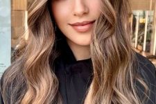 19 long wavy brunette hair with a very delicate and modern money piece that looks like a flash of light