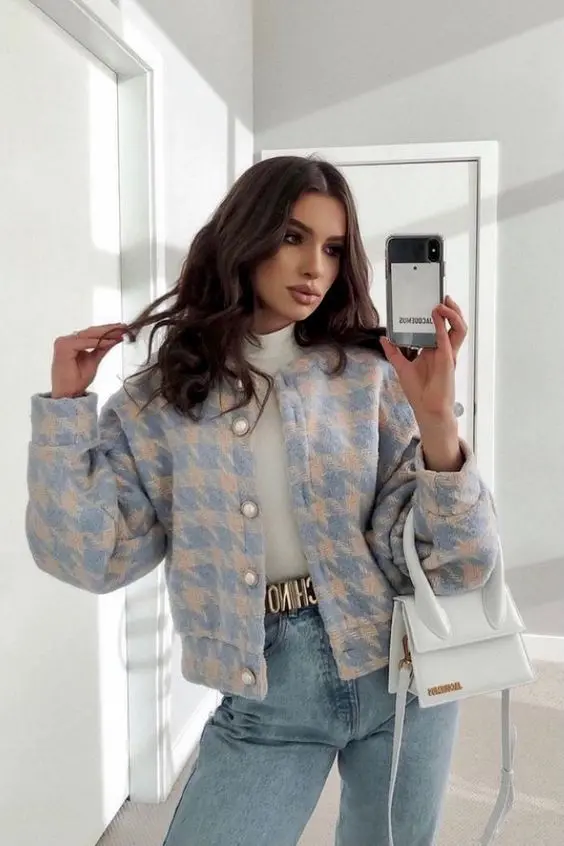 a preppy look with a white turtleneck, blue high waisted jeans, a pastel tweed cropped jacket with pearl buttons and a white bag